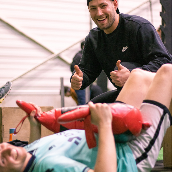 Coach en sporter lachen tijdens een training